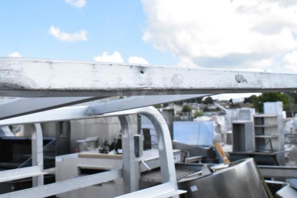 2 metal commercial pan transport racks with white finish and commercial casters, 1 caster missing. Slight wear visible.