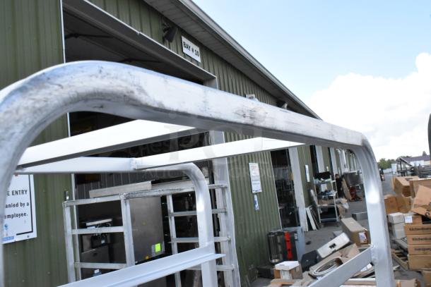 2 metal commercial pan transport racks on casters; one missing a caster. Visible signs of wear. Auction includes two units.