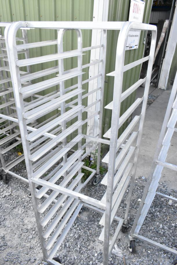 2 metal commercial pan transport racks on casters, excellent condition, multiple shelves, ideal for kitchen use.