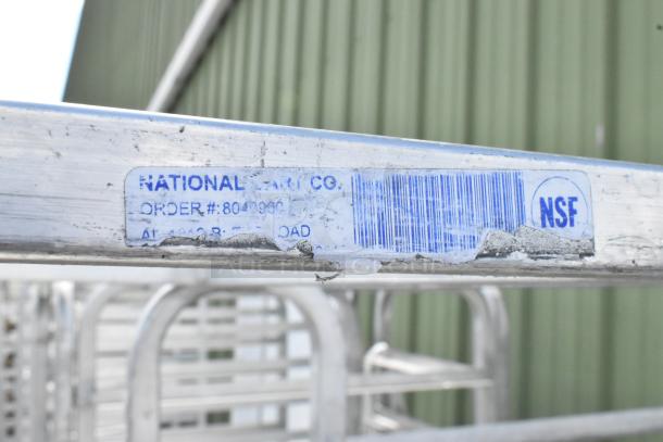 2 metal commercial pan transport racks with casters, labeled "National Cart Co." and NSF certified, order #: 8049901.