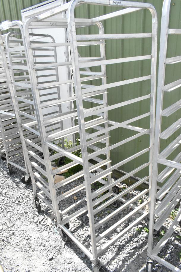 2 metal commercial pan transport racks on casters, sturdy design, suitable for kitchen use, visible wear.