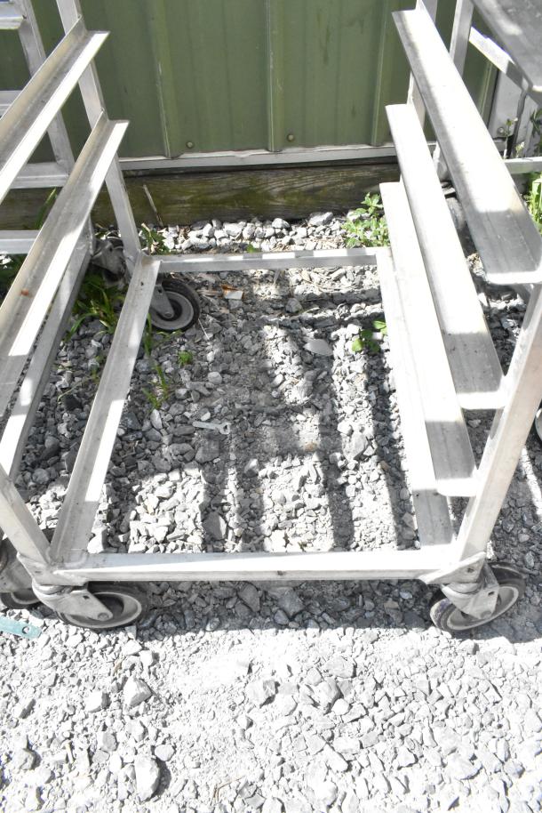 2 metal commercial pan transport racks with multiple shelves on sturdy commercial casters for easy mobility, in good condition.