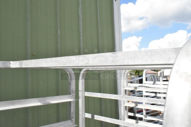 2 metal commercial pan transport racks on casters, used condition, sturdy metal frame, ideal for kitchens or bakeries.