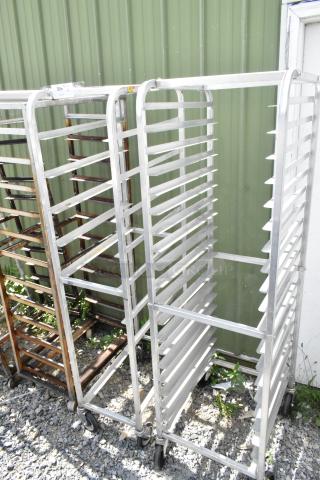 2 metal commercial pan transport racks with multiple shelves, on commercial casters, used condition. Auction tag visible.