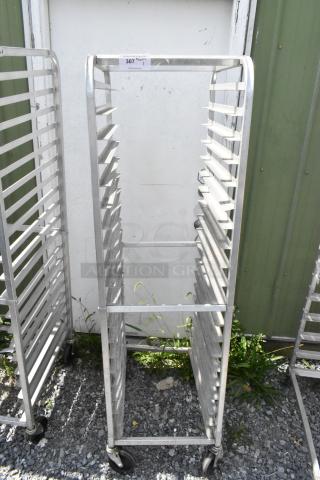 Metal commercial pan transport rack on casters, used condition, multiple slots for trays, label with the number "307".