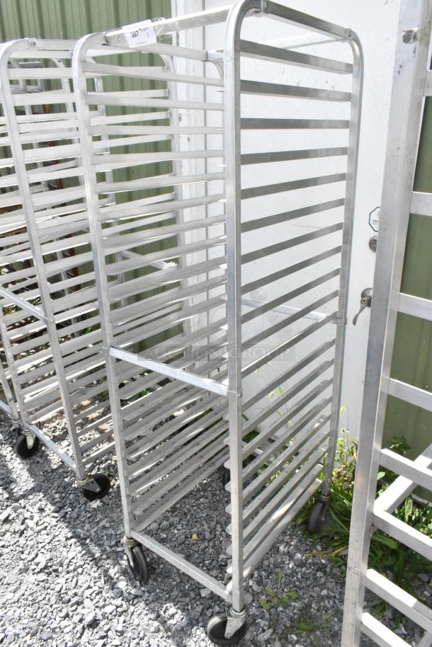 Metal commercial pan transport rack with multiple shelves on commercial casters, in good condition.