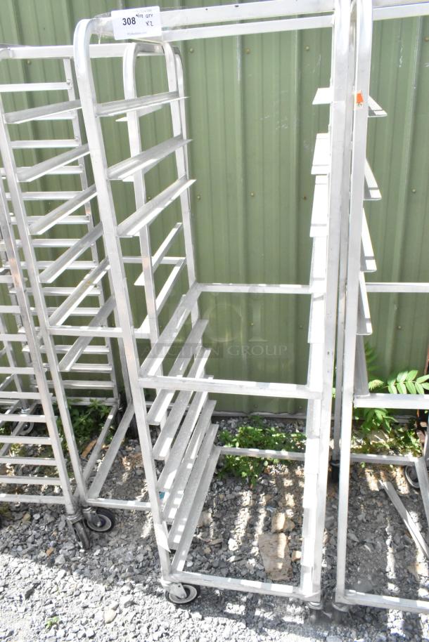 Two metal commercial pan transport racks with multiple shelves and commercial casters, in good condition.