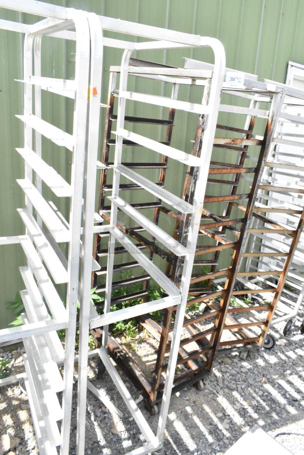 2 metal commercial pan transport racks with multiple shelves, on commercial casters. Used condition, outdoors.