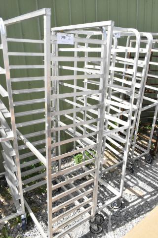 2 metal commercial pan transport racks on casters, used condition, multiple shelves, labeled "309 x2" for inventory.