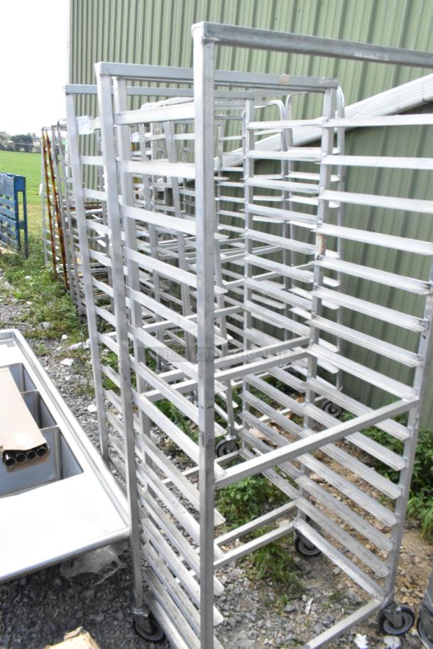 Metal commercial pan transport rack with multiple slots, commercial casters, used condition, 2 units available.