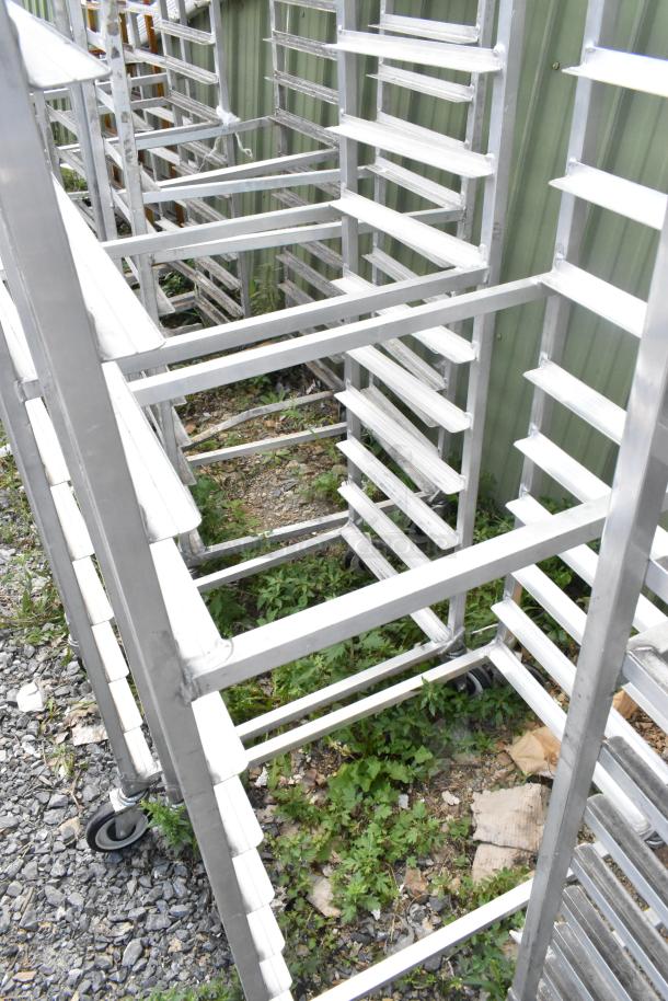 Two metal commercial pan transport racks with durable commercial casters, designed for easy mobility and efficient pan storage.