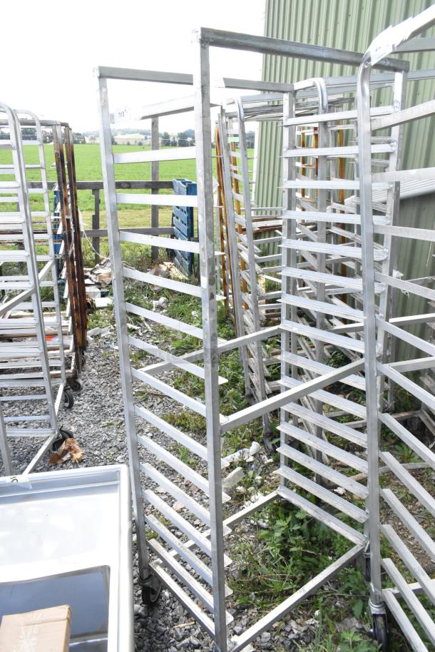 Commercial metal pan transport rack on casters, sturdy frame, 18 slots, outdoor setting, used condition.