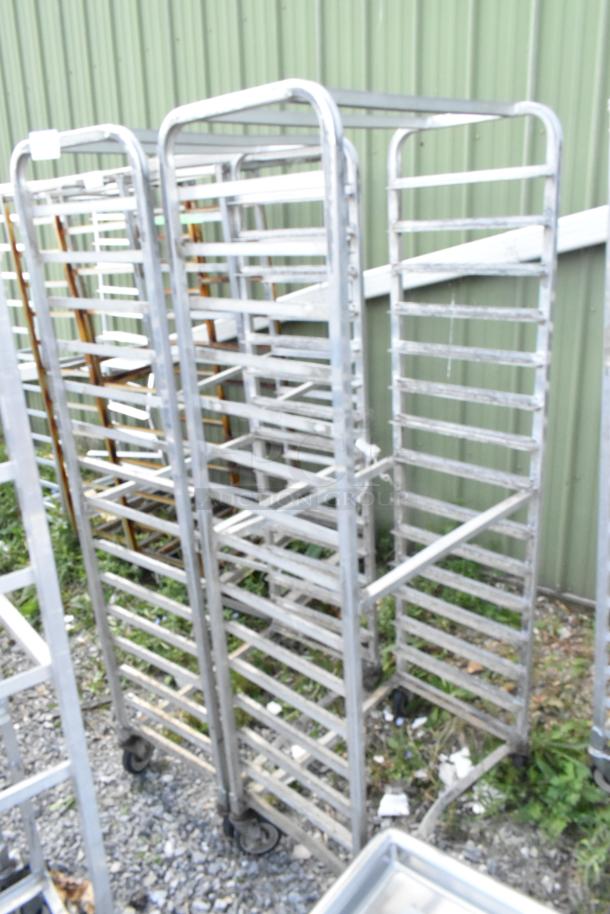 2 metal commercial pan transport racks with multiple shelves, mounted on commercial casters, in used condition.