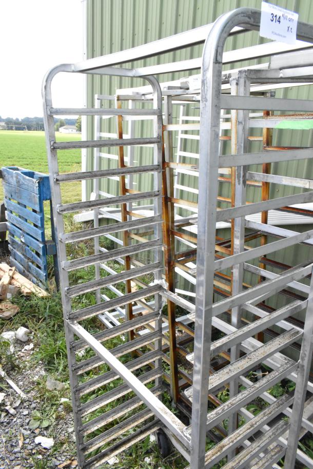 2 metal commercial pan transport racks on casters, outdoor setting, signs of rust, auction label "314".