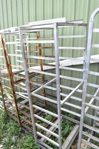 2 metal commercial pan transport racks with casters and oven guide. Some rust present. Ideal for bakery or kitchen use.
