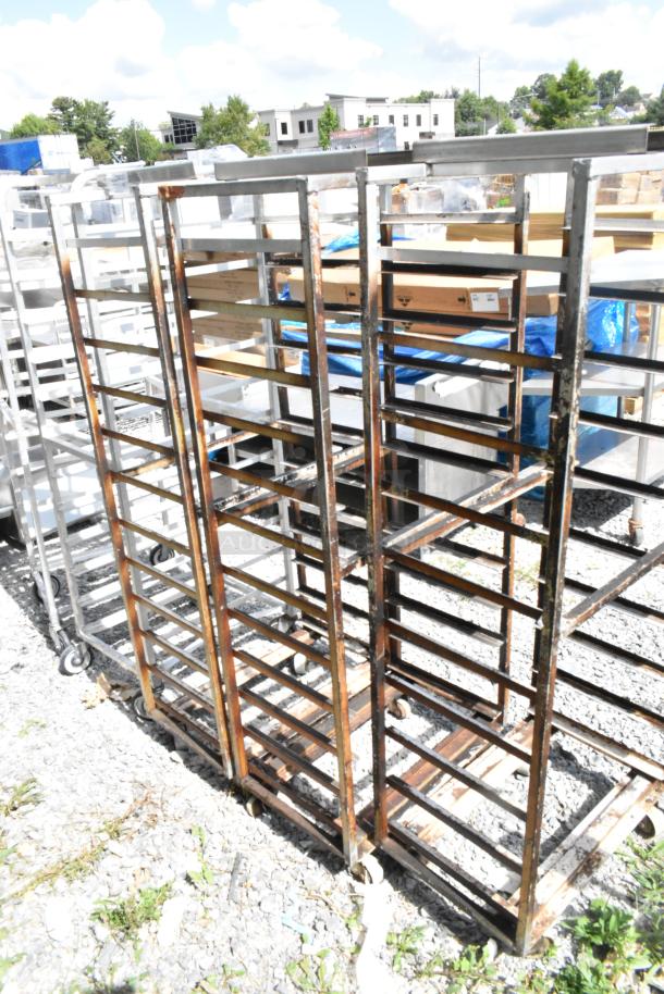3 metal commercial pan transport racks on casters, rack oven guide included, used condition, outdoor setting.