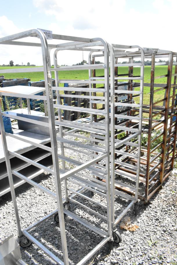 Two metal commercial pan transport racks on commercial casters; sturdy design, ideal for bakery or kitchen use.