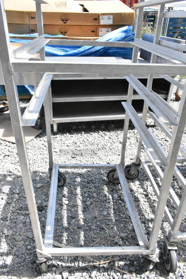 2 metal commercial pan transport racks with sturdy frames on commercial casters, ideal for kitchen use.
