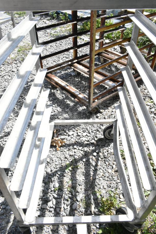 2 metal commercial pan transport racks on casters; durable construction, suitable for heavy-duty use, visible wear.