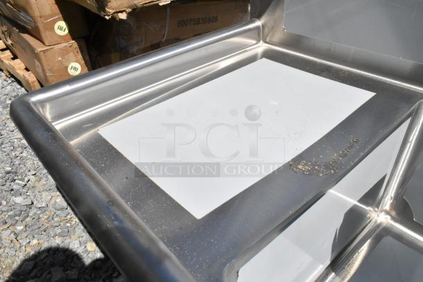 Brand new Steelton 522CS31620LR stainless steel 3 bay sink with dual drain boards, minor scratches and dents visible.