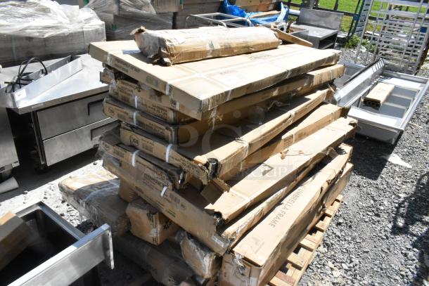 Stack of boxed items including over shelves, wire shelves, and patio umbrella frames; some boxes show minor wear.