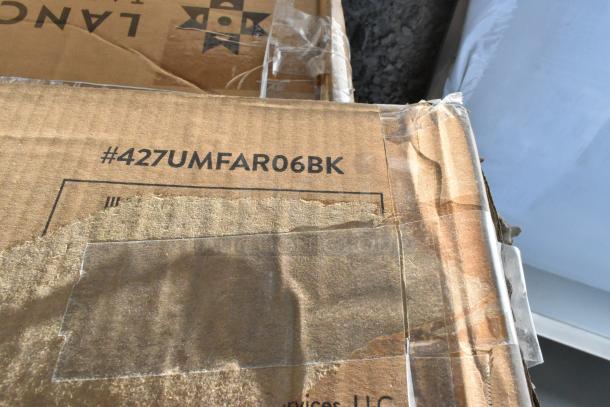 Cardboard box labeled "#427UMFAR06BK," possibly containing scratch and dent items like shelves and umbrella frames.
