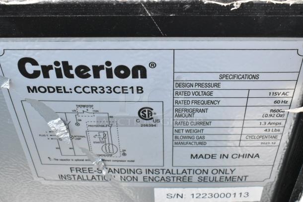 Label on Criterion CCR33CE1B cooler showing specs: 115VAC, 60Hz, R600a refrigerant, net weight 43 lbs, made in China.