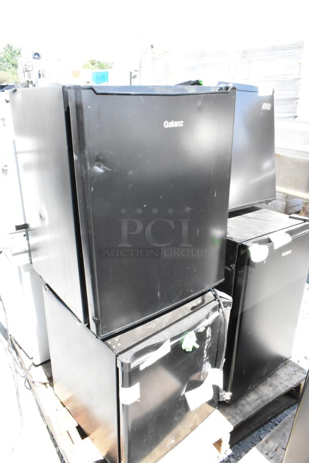 Eight mini coolers including Galanz, Hisense, and Arctic King models. Black, dented condition, 115V, 1 phase. Auction lot.