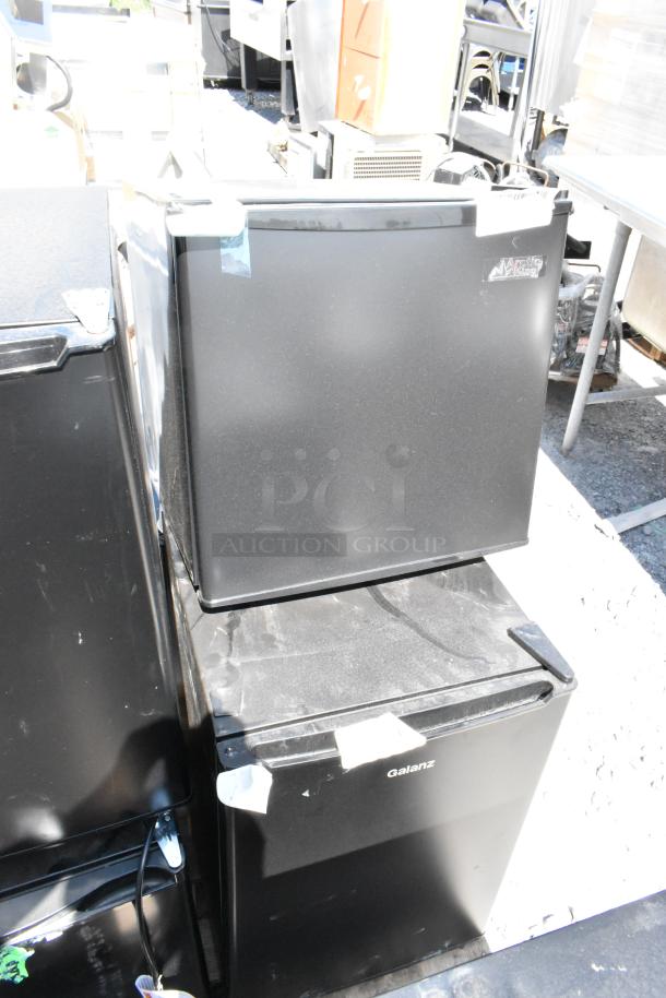 Eight mini coolers including Galanz and Arctic King models, stacked outdoors. Some have visible brand labels and minor wear.