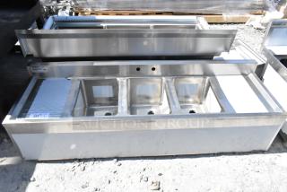 Brand new Regency 600B31014213 stainless steel 3-bay back bar sink with dual drain boards, visible minor scratches.