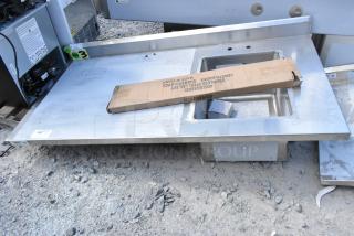 BRAND NEW SCRATCH AND DENT Regency 600ST3060R Stainless Steel Table with Sink Bay. Includes packaging box and visible minor scratches.