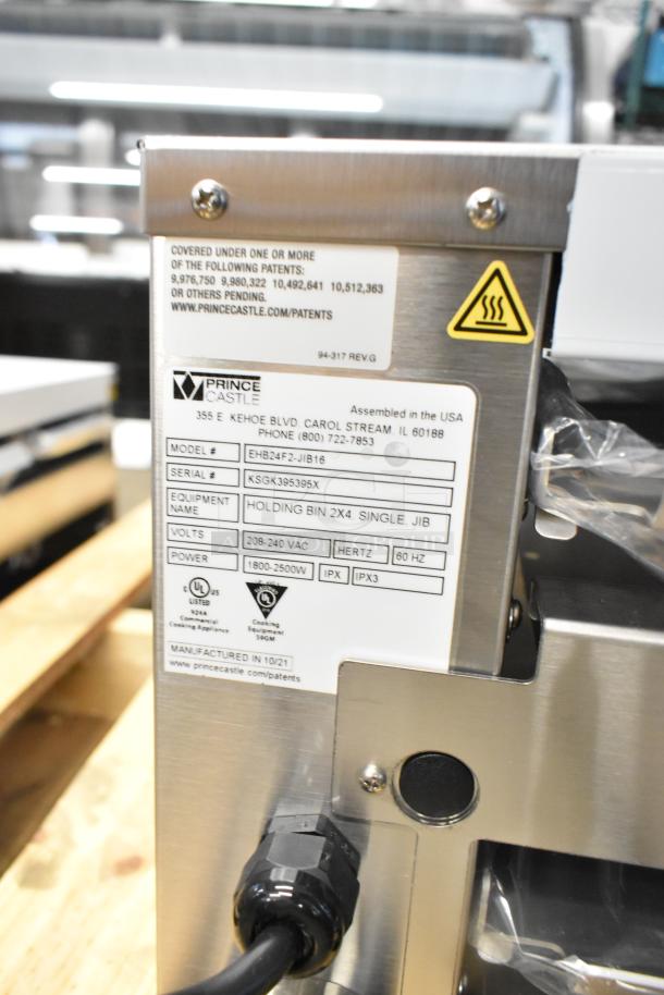 Brand new Prince Castle EHB24F2-JIB16 stainless steel holding bin with power label, 208-240V, 1-phase, model information visible.