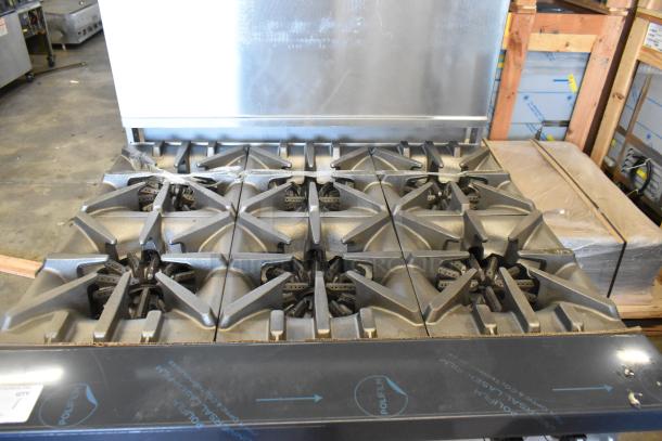 Brand new Garland G36-6 stainless steel commercial range with 6 burners, standard oven, overshelf, and backsplash. Scratch and dent condition.