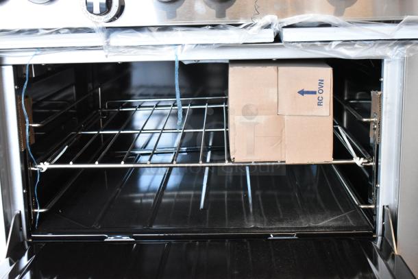"Garland G36-6 Stainless Steel Commercial 6 Burner Range with oven, over shelf, and back splash. New, minor scratches."