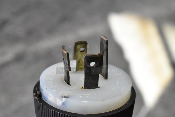 Close-up of a plug connector for a Taylor C723-33 ice cream machine, showing metal prongs and white plastic base.