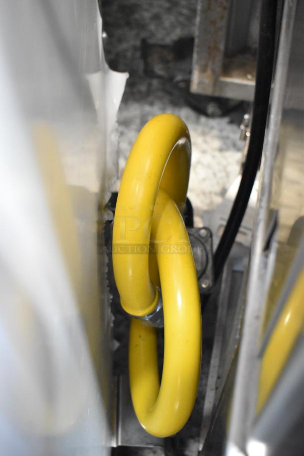 Yellow commercial gas hose connection on Toastmaster TCT-1627 R Tandoor Oven, indicating natural gas setup.