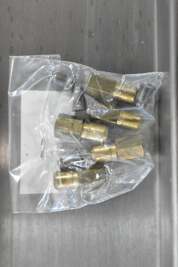 Plastic bag with brass fittings for Avantco 177CAG60TG griddle, suggesting new condition, on stainless steel surface.