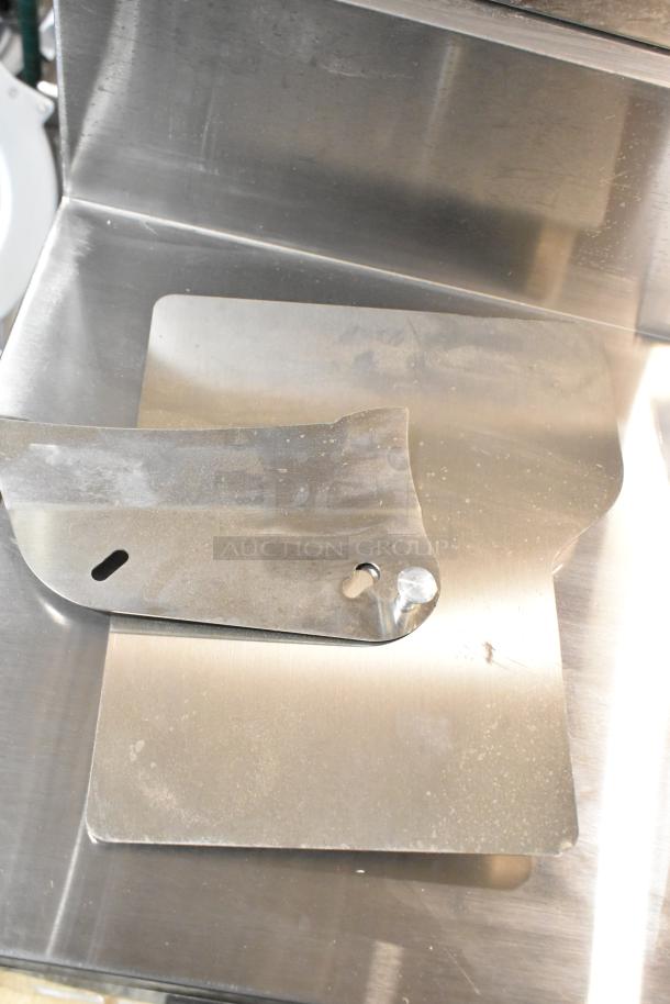 Stainless steel part of Estella 348SLAS13 meat slicer, showing visible scratches and dents.