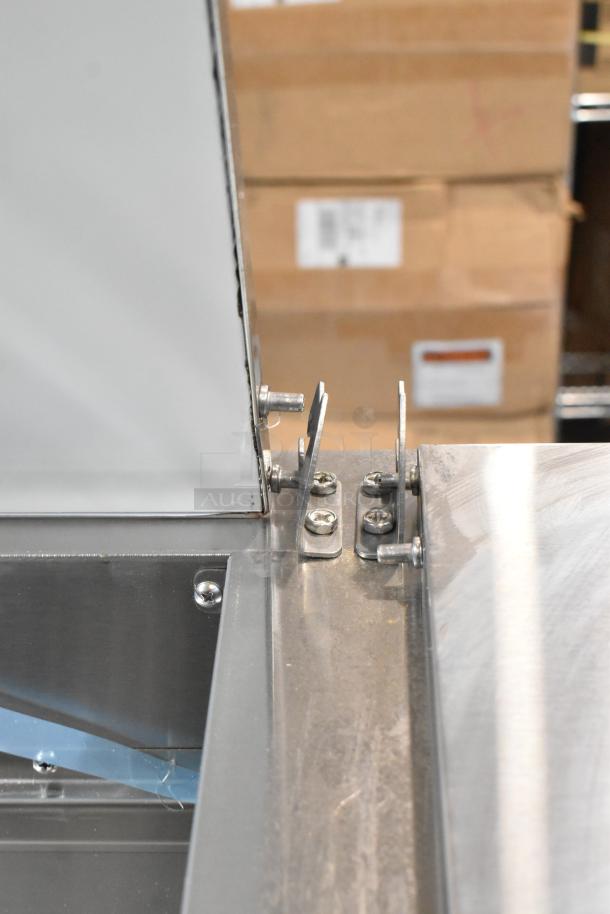 Brand new Avantco 178SSPPT3 stainless steel commercial pizza prep table hinge detail, minor scratch visible.