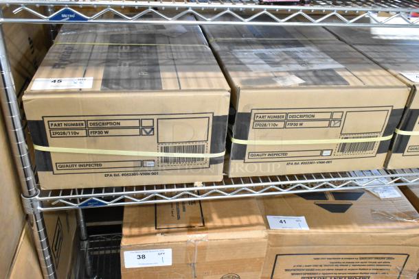 2 brand new FTP30 W insect light traps in boxes, labeled with part number ZF028/110v, quality inspected, on metal shelving.
