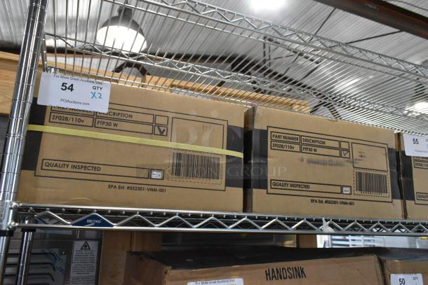 Two brand new FTP30 W insect light traps in boxes on metal shelf, marked "Quality Inspected" with part number ZF028/110v.