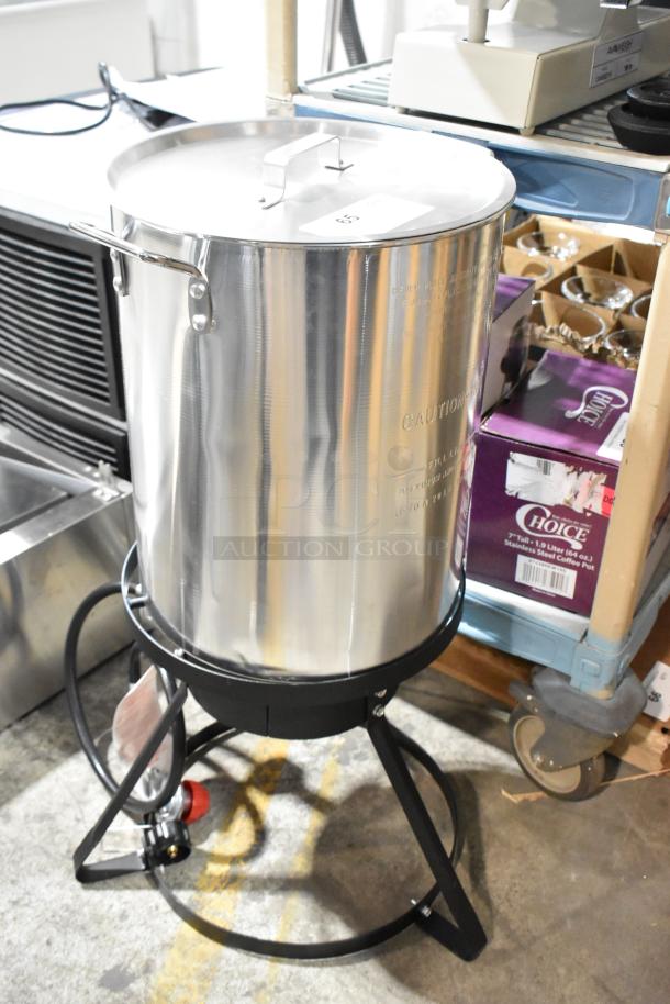 Brand new single burner propane gas range with deep fryer stock pot. Metal construction, minor dents visible.