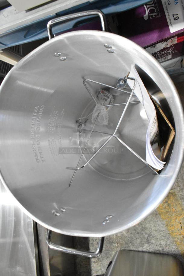 Brand new metal propane gas-powered single burner range with deep fryer stock pot, includes rack and manual, minor dent visible.