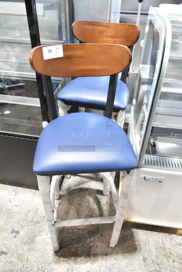 2 brand new black metal bar stools with wooden backrests and blue seat cushions. Scratch and dent condition.