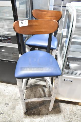 2 brand new black metal bar stools with wooden backrests and blue seat cushions. Scratch and dent condition.