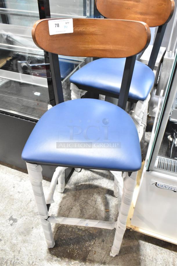 Brand new black metal bar height chair with wooden backrest and blue seat cushion; tag indicates quantity 2.