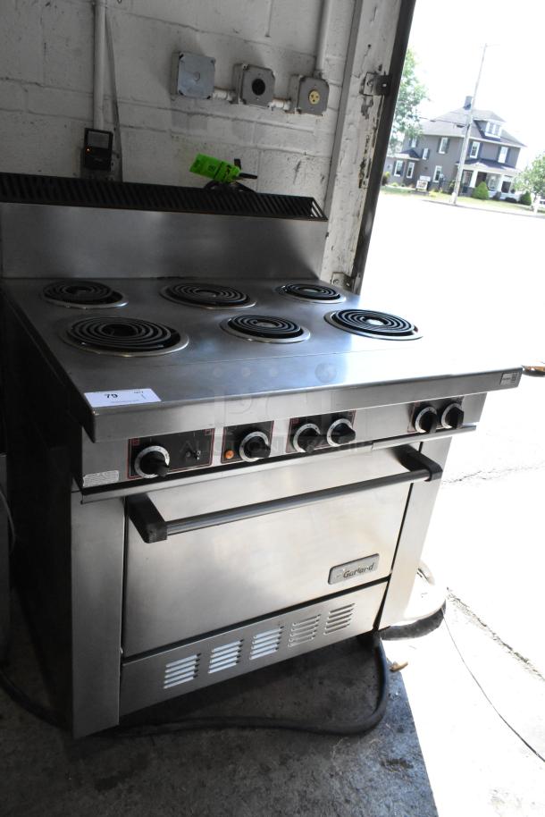 Garland stainless steel 6-burner range with oven, commercial casters, electric, 120/250V, 3 phase, in good condition.