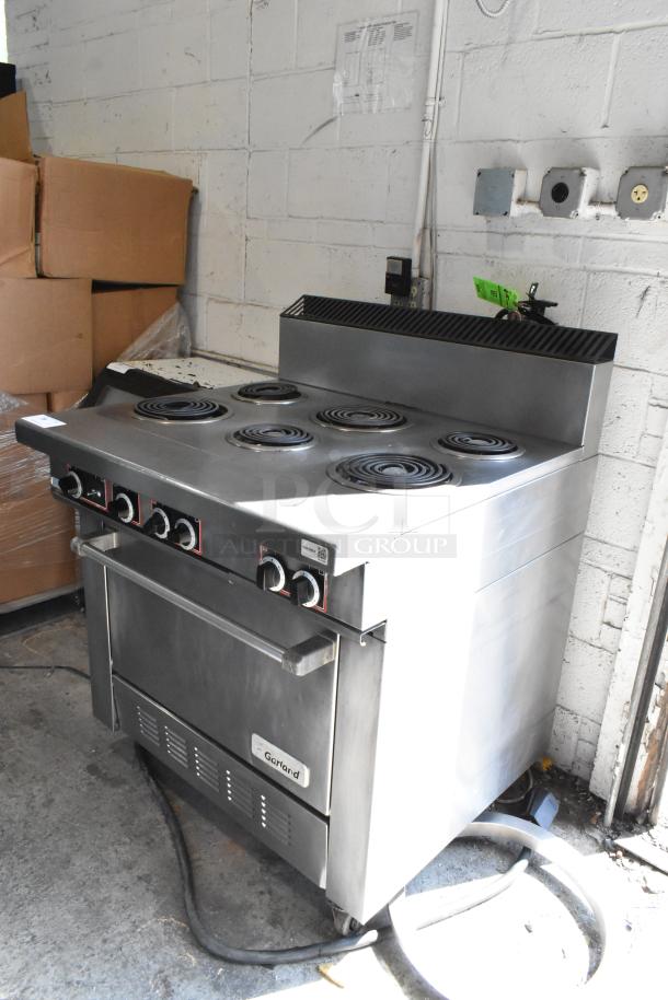 Garland stainless steel 6-burner electric range with oven, commercial casters, 120/250V, 3-phase, used condition.