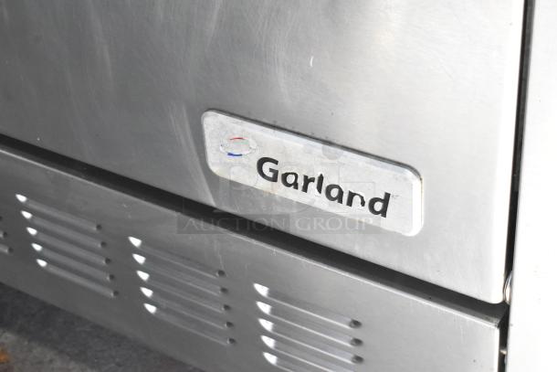 Garland stainless steel commercial electric 6-burner range with oven, features 120/250 volts, 3 phase, on casters, logo visible.
