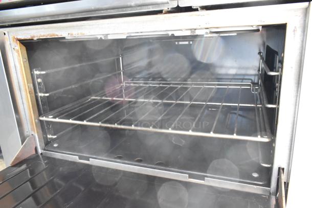 Garland stainless steel commercial electric 6-burner range with oven on casters. 120/250V, 3 phase. Visible wear inside oven.